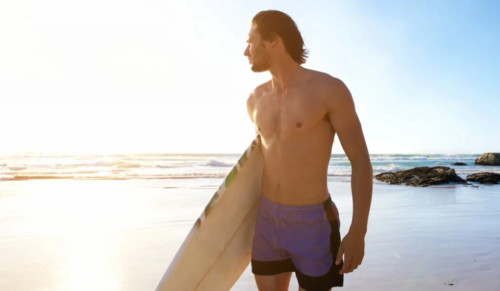 surfer carrying board