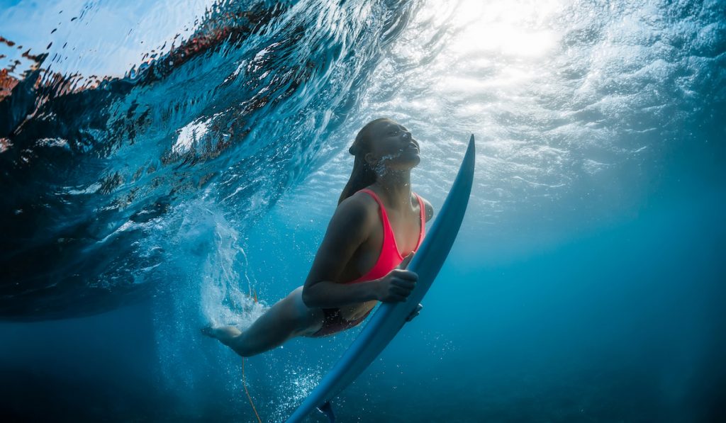 surfer diving under a rolling wave