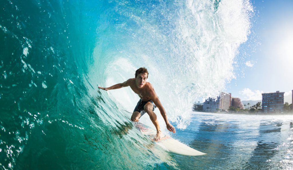 surfer under a wave