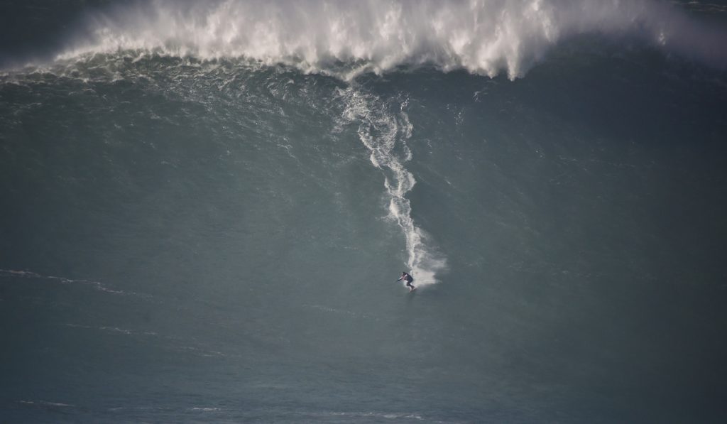 surfing a monster wave in portugal