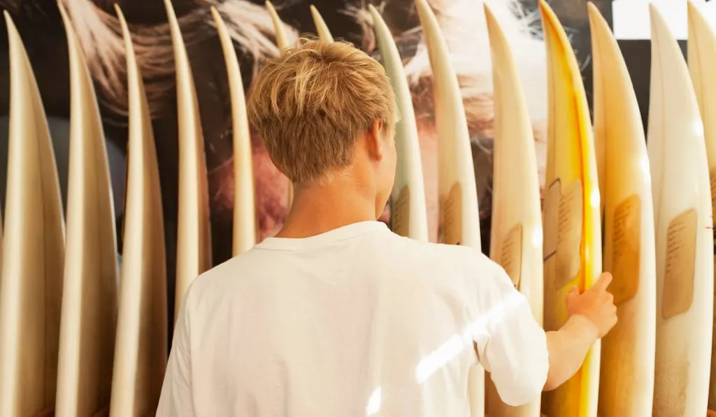 young boy looking to buy his first surfboard