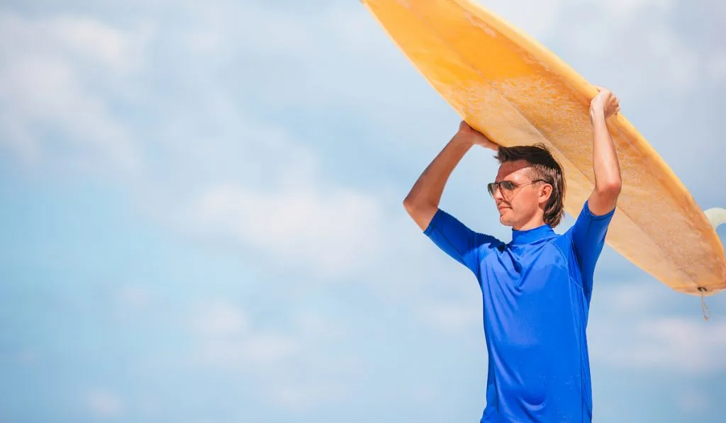 young man with yellow surfboard