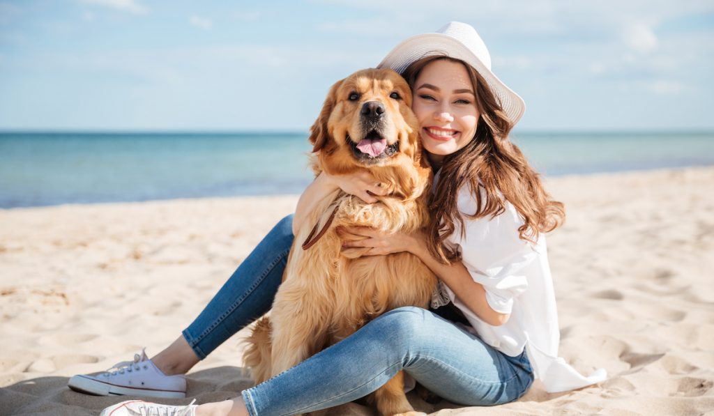 young woman with her dog at the beach
