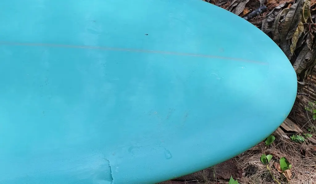 dented light blue surfboard