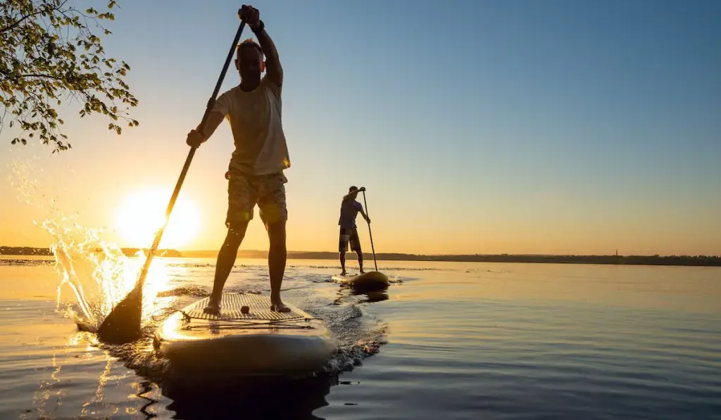 man stand up paddle boarding 
