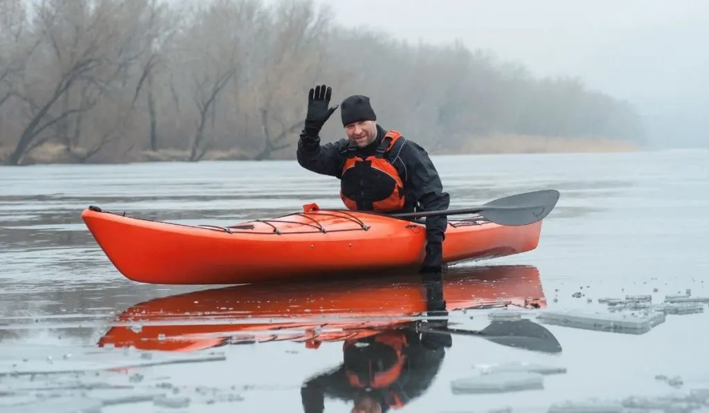 male kayaker waiving with gloves in the winter - ss220324
