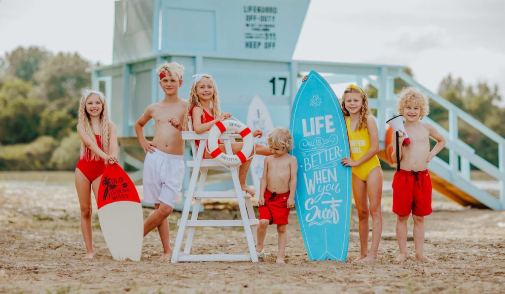 Six cute kids with surfboards on the beach