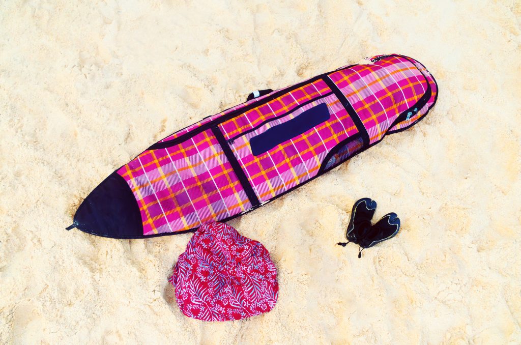 Surf bag with a board on a white sand