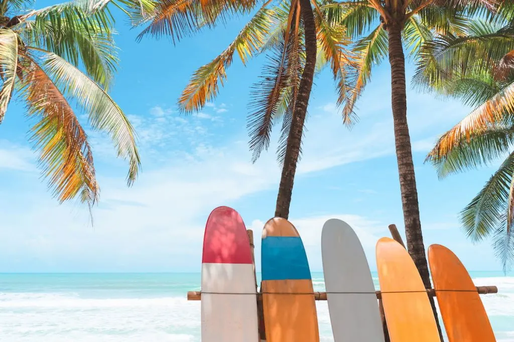 Surfboard and palm tree on beach background