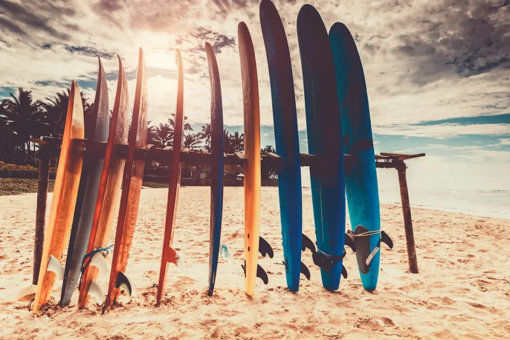 many different surf boards on the beach