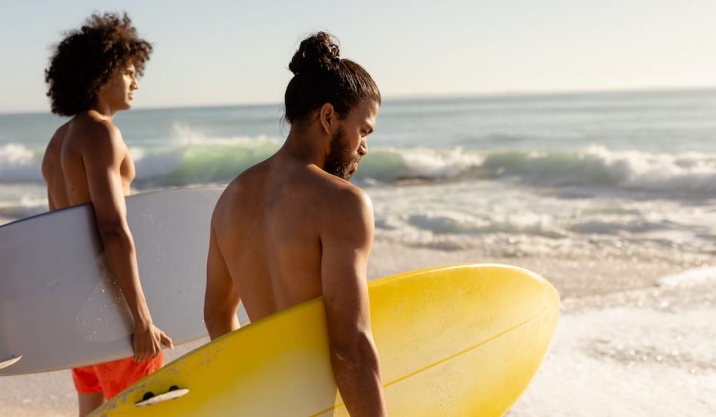 multi-ethnic-males-holding-surfboards-on-the-beach