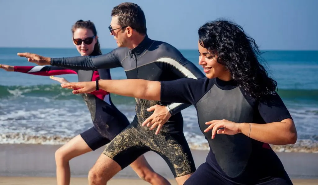 surf-instructor-and-two-girls-beginner-surfers