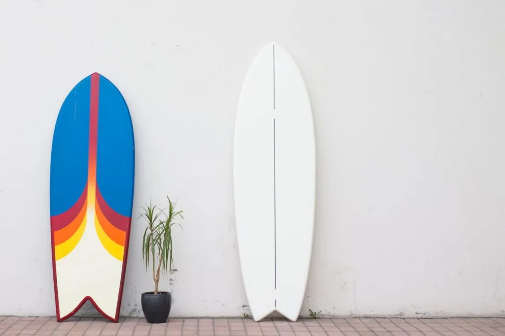 two surfboards on the street near the wall for hire rent 