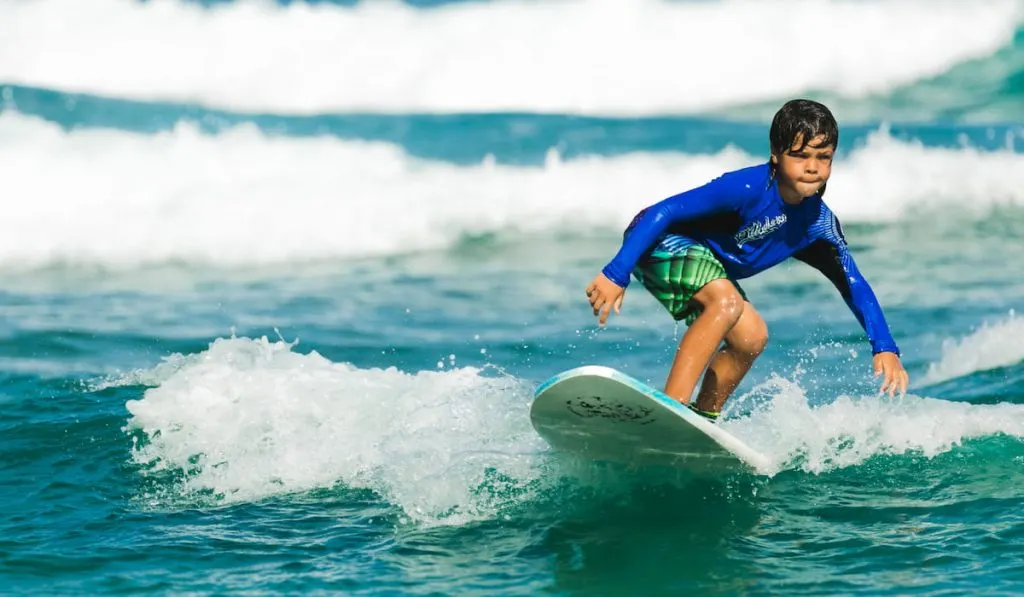 young kid surfing on the ocean