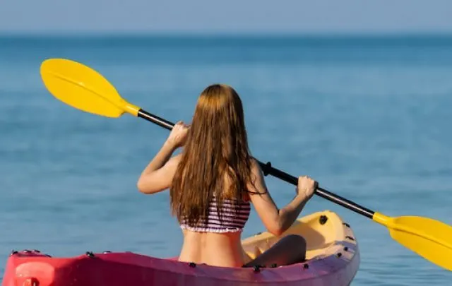 woman in swimsuit paddling a kayak boat in the sea - ss220812