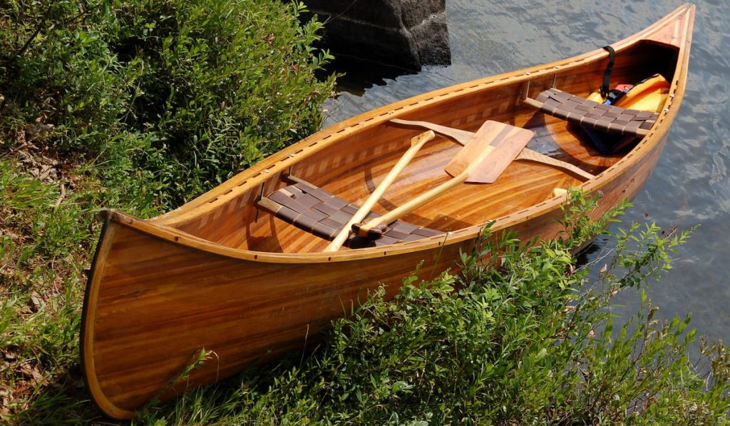 Handcrafted cedar strip canoe on shore