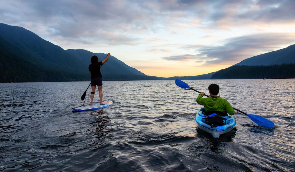 friends on lake kayaking and paddleboarding together - ee221208