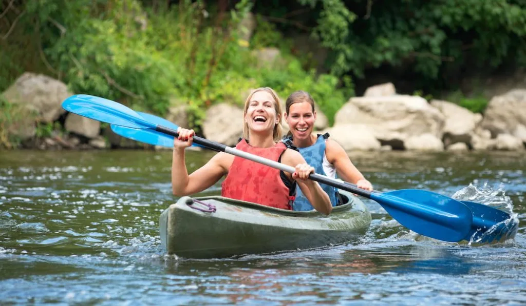 young women kayaking down a river 