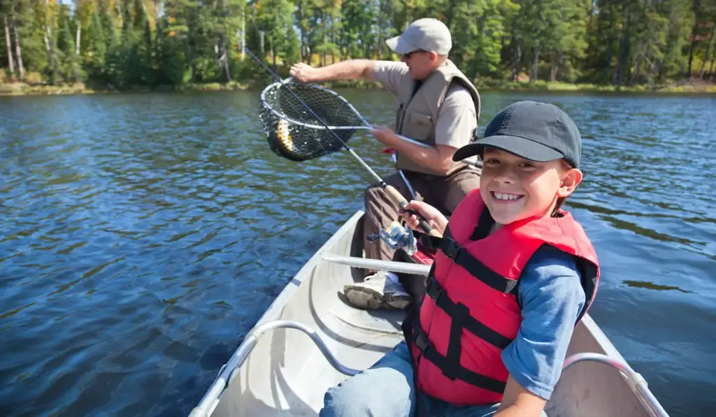 Boy and father fishing in a canoe 