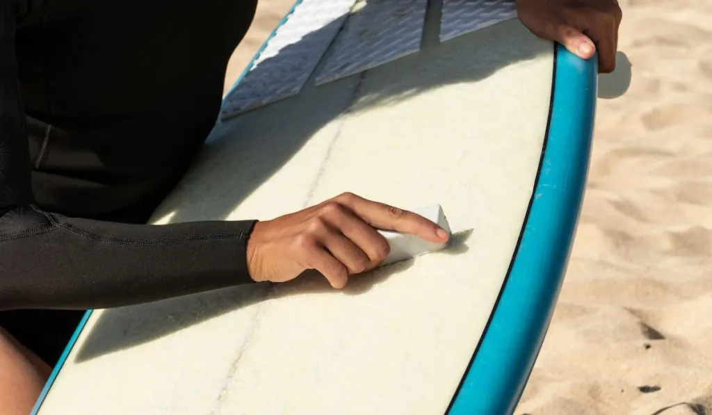 Hand waxing surfboard