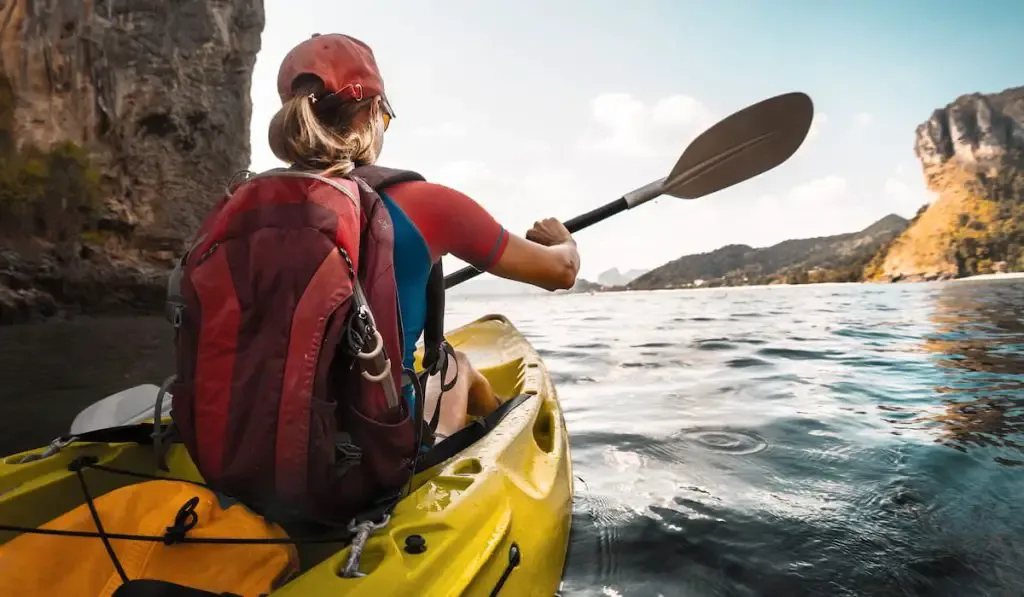 lady paddling the kayak in the calm bay 