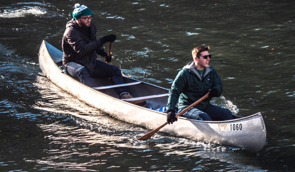 two men paddle their aluminum canoe