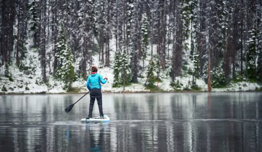 woman on paddle board in winter