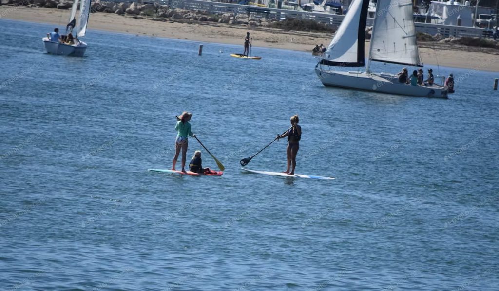 family paddle boarders on the beach