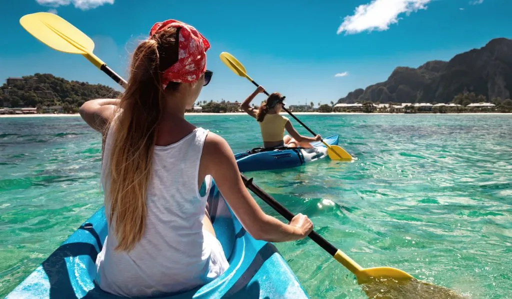 two women kayaking in the river 